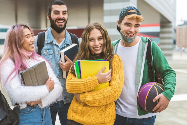 Heureux les jeunes se réunissant à l'extérieur et portant des masques faciaux pendant la pandémie de covid19