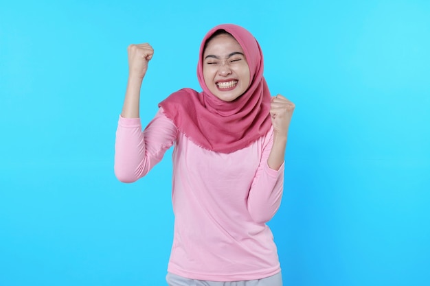 Heureux joyeux portant le hijab et le t-shirt rose obtiennent de bons résultats, les sourires étant généralement de bonne humeur