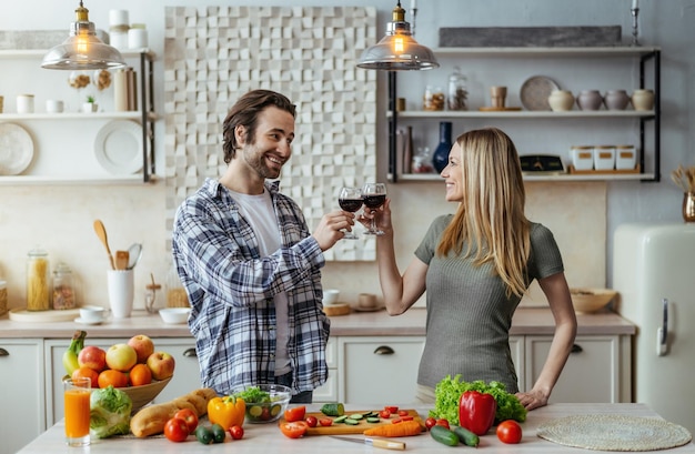 Heureux mari caucasien millénaire avec chaume et femme préparant le dîner avec des légumes biologiques