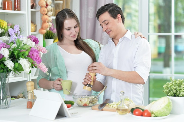 Heureux mari et femme cuisinant ensemble dans la cuisine