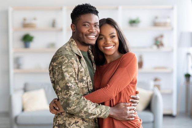 Heureux mari et femme militaires de la famille afro-américaine embrassant à la maison