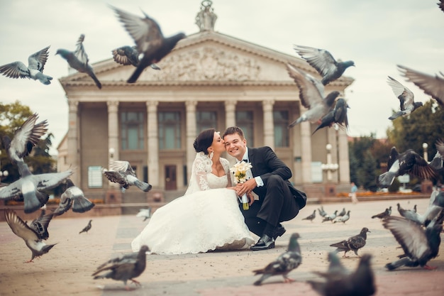 Heureux mariés s'embrassant entre pigeons