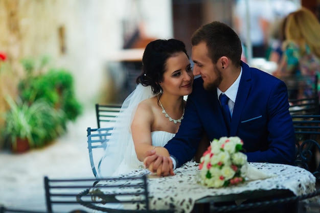 Heureux mariés s'embrassant à table