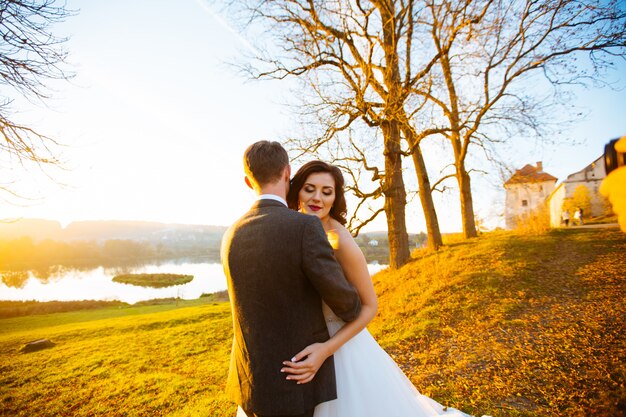 Heureux mariés souriants marchant à l'extérieur, embrassant et embrassant le jour de leur mariage