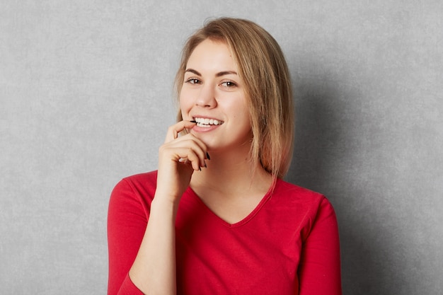 Heureux modèle féminin heureux vêtu de vêtements rouges