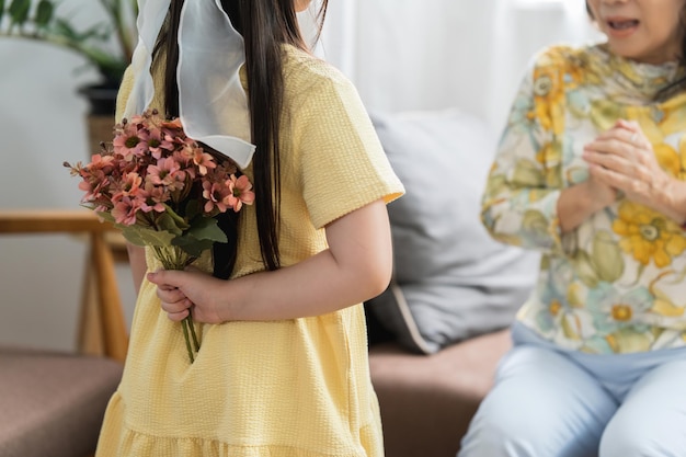 Heureux moment de petite fille surprendre sa mère aimante en vacances en offrant des fleurs