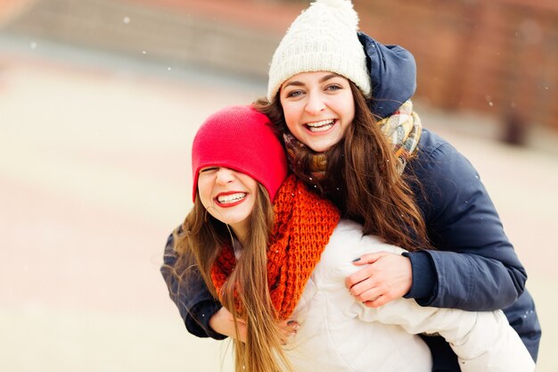 Heureux moments positifs lumineux de deux filles élégantes étreignant dans la rue en ville.