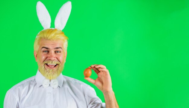 Heureux les oeufs de pâques chassent l'homme barbu avec la préparation de gars de lapin d'oeuf pour pâques