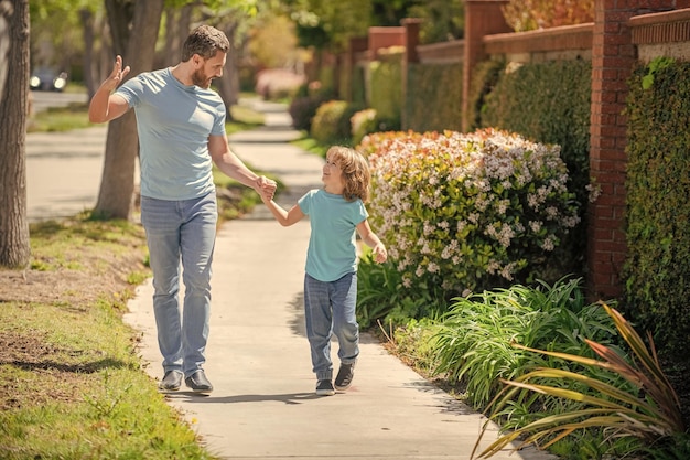 Heureux papa avec enfant marcher ensemble dans le parc l'été