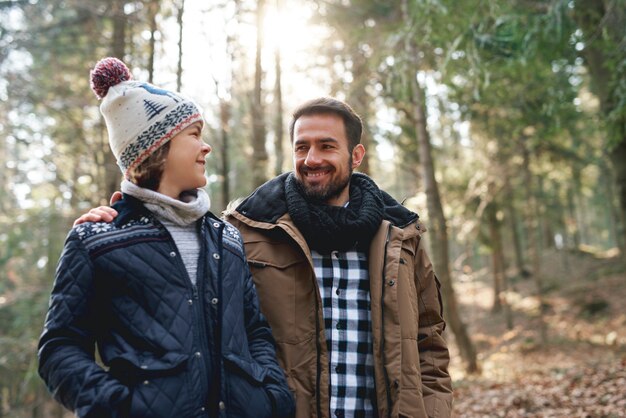 Heureux papa et fils adolescent marchant dans la forêt d'automne