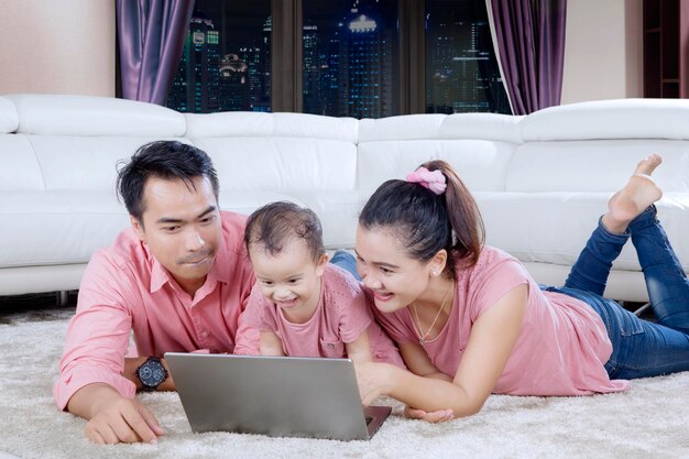 Heureux parents à l'aide d'un ordinateur portable avec enfant