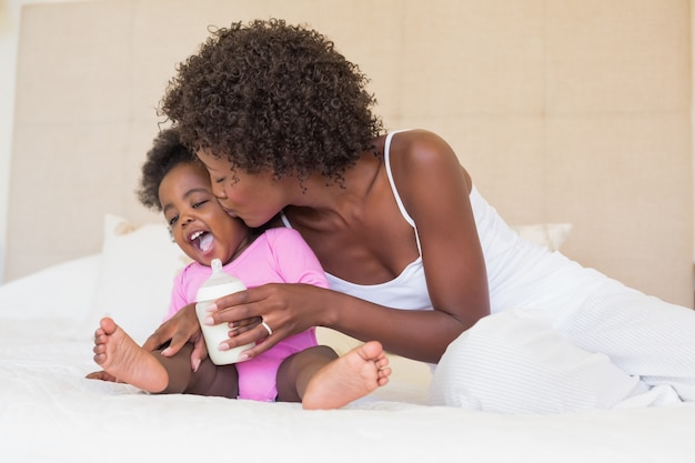 Heureux parents avec bébé sur leur lit