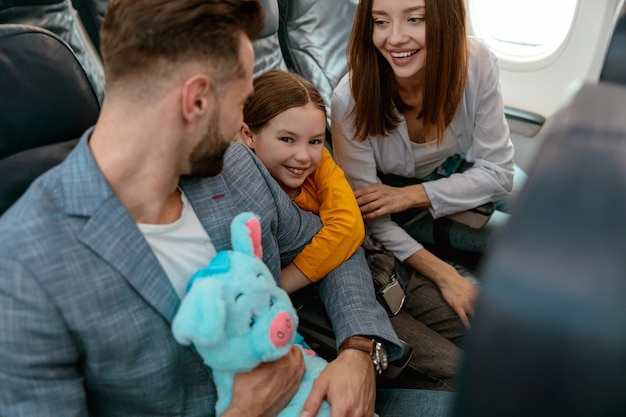 Heureux parents avec enfant voyageant en avion