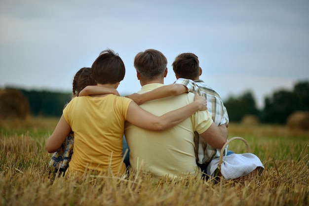 Heureux parents et enfants au champ de blé d'été