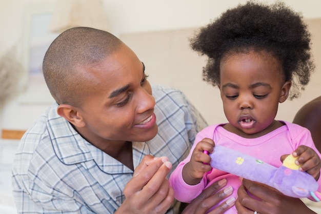 Photo heureux parents jouant avec bébé fille sur le lit ensemble