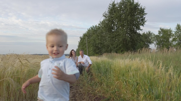 Heureux parents jouant avec un enfant sur un champ de blé