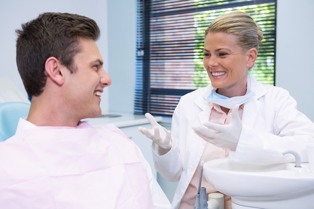 Heureux patient discutant avec le dentiste