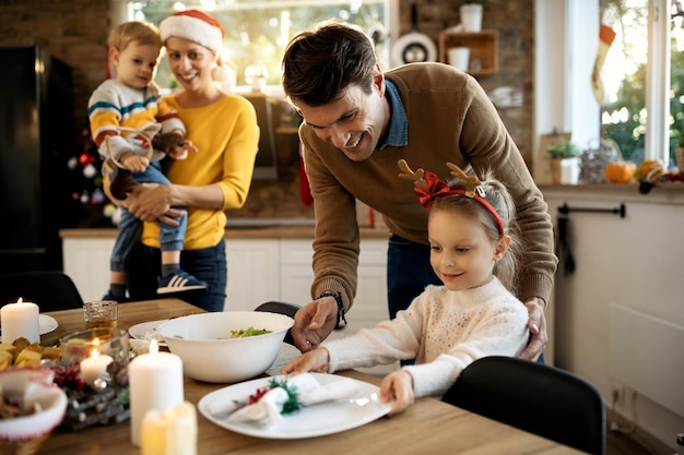 Heureux père et fille établissant une table à manger le jour de Noël