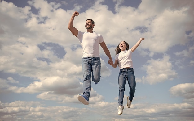Heureux père et fille sautent dans le ciel brillant avenir