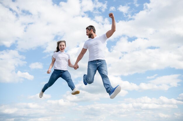 Heureux père et fille sautent dans le ciel