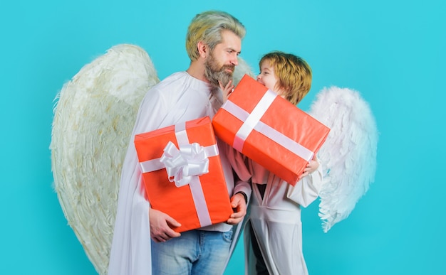 Heureux père avec fils en costume d'ange avec cadeau