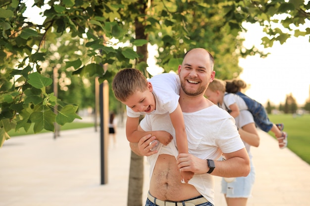 Heureux père et fils de famille s'amusant dans le parc. un homme tenant un enfant sur ses épaules