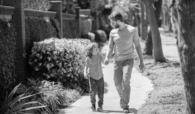 Heureux père avec fils marchant ensemble dans le parc famille heureuse