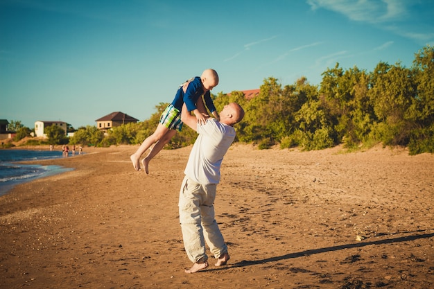 Heureux père et fils marchant sur la plage