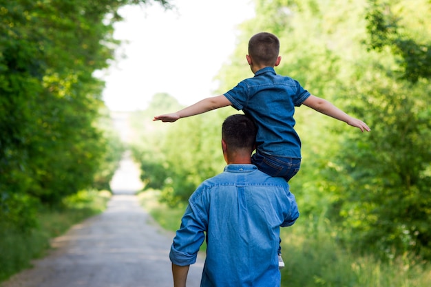 Heureux père et fils marchent le long de la route