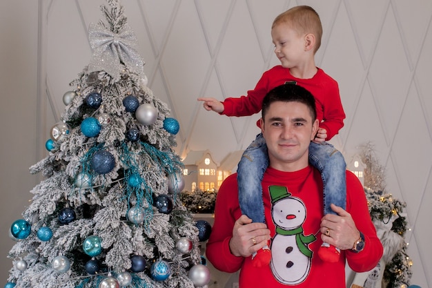 Heureux père et fils profitant de la décoration de l'arbre de Noël avec des boules de Noël