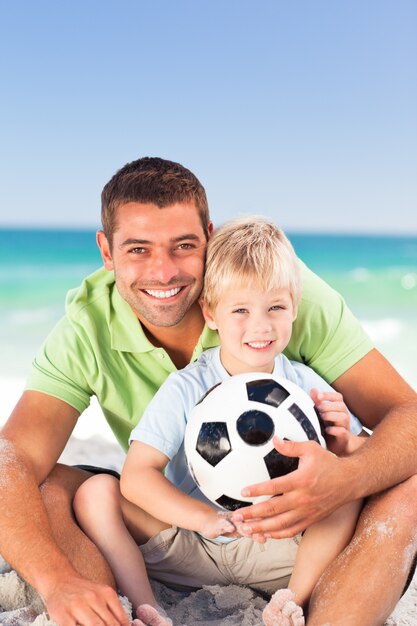 Heureux père jouant au football avec son fils