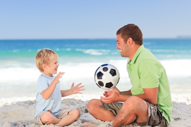 Heureux père jouant au football avec son fils