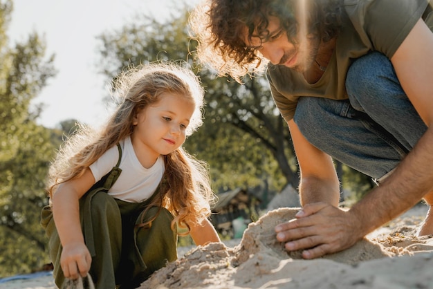 Heureux père passant du temps amusant avec sa petite fille à la plage