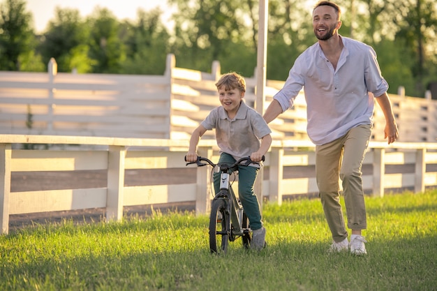 Heureux père et petit fils faisant du vélo ensemble