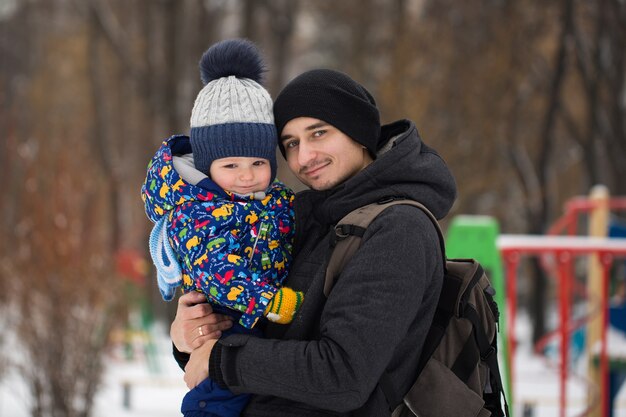 Heureux père et petit garçon dans la neige de l'hiver