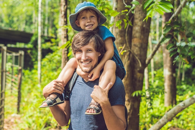 Heureux père et petit garçon marchant dans le parc d'été. concept d'adoption et de personnes