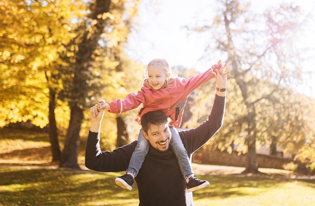 Heureux père avec petite fille dans les loisirs de plein air du parc d'automne Père et fille