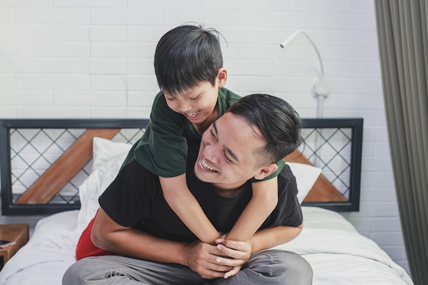 Heureux père portant son fils et souriant ensemble