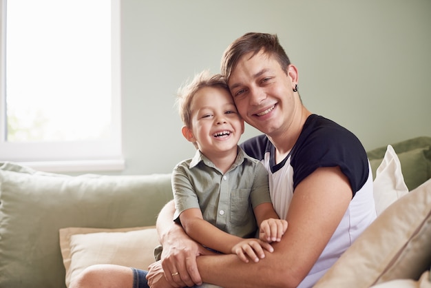 Heureux père avec son fils d'un an jouant à la maison sur le lit