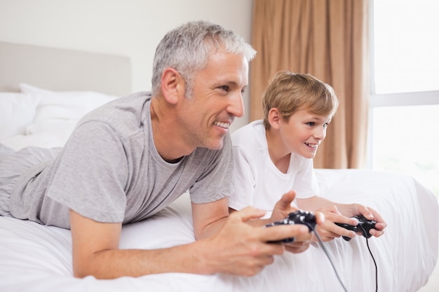 Heureux père et son fils jouant à des jeux vidéo