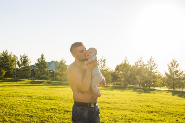 Heureux père tenant bébé fils, jetant bébé dans l'air. Concept de famille heureuse, fête des pères et enfant