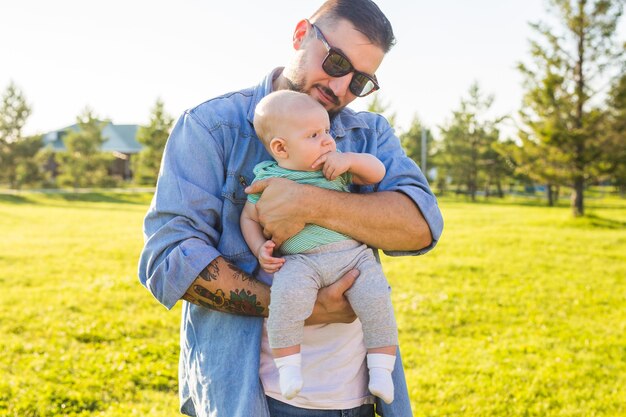 Heureux père tenant son bébé sur le concept de la nature de la fête des pères de famille heureuse et de l'enfant