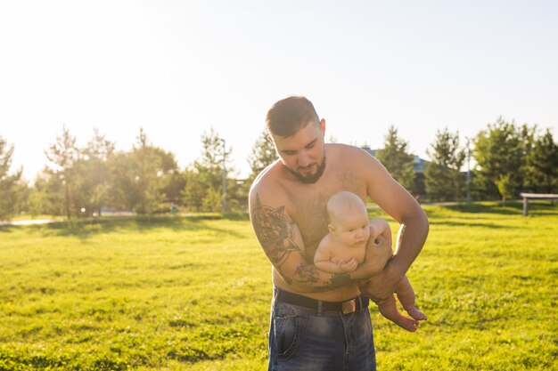 Heureux père tenant son bébé sur le concept de la nature de la fête des pères de famille heureuse et de l'enfant