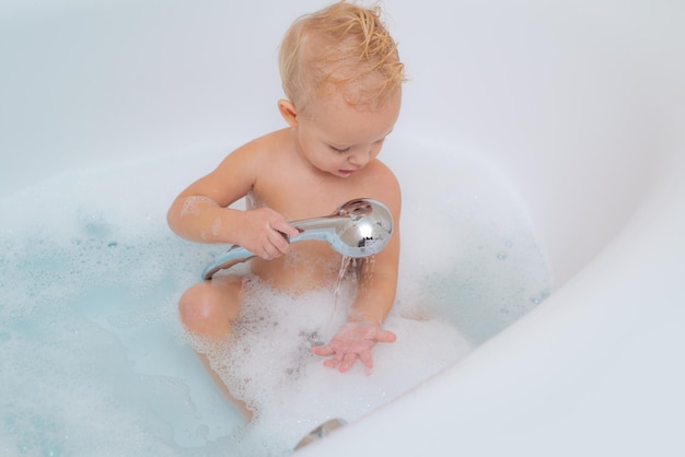 Heureux petit bébé garçon s'amusant à se baigner Joli bébé riant heureux dans un peignoir doux après le bain jouant dans la chambre des enfants Hygiène et soins de santé