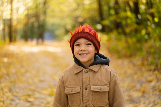 Heureux petit enfant bébé garçon riant et jouant dans la journée d'automne enfant joue avec des feuilles