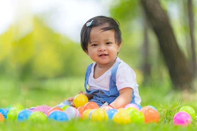 Heureux petit enfant et boules colorées dans le parc