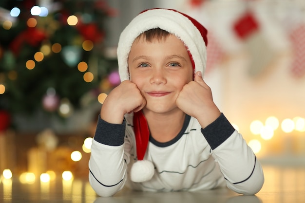 Heureux petit garçon en bonnet de Noel à la maison