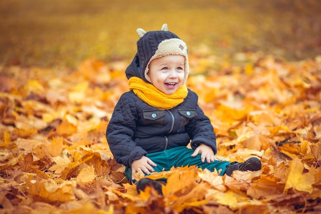 Heureux petit garçon dans le parc d'automne