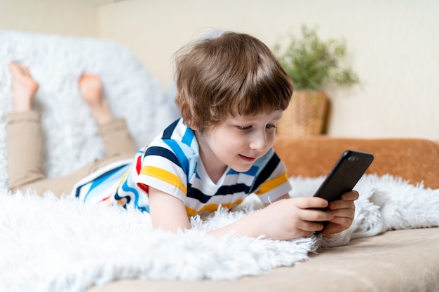 Heureux petit garçon enfant jouant au jeu en ligne