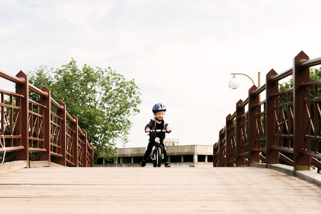 Photo heureux petit garçon, faire du vélo dans le parc